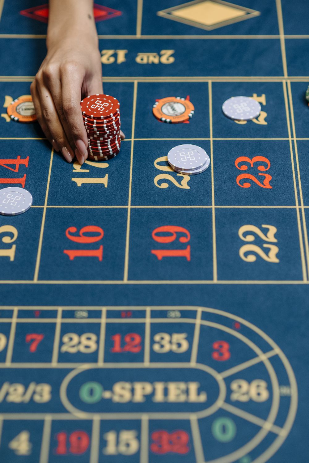 Chip taruhan tertata di atas meja kasino